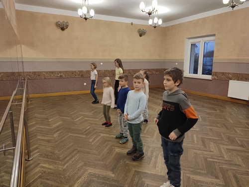 Zdjęcie przedstawia siedmioro dzieci tańczących na sali lustrzanej