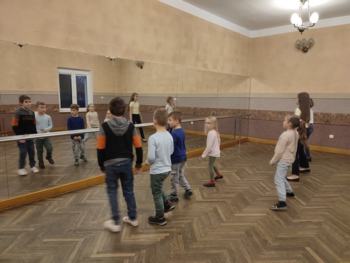 Zdjęcie przedstawia siedmioro dzieci tańczących na sali lustrzanej