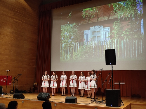 Na scenie stoi siedem dziewczyn trzymających mikrofony(187KB).jpg